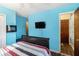 A quaint bedroom painted blue with a flatscreen TV mounted on the wall at 989 Queen Elizabeth Way, Morrow, GA 30260