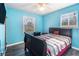 A clean bedroom painted blue with windows and a ceiling fan at 989 Queen Elizabeth Way, Morrow, GA 30260