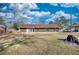 Back of home with grass and a bit of a tree stump. Blue skies with some clouds overhead at 11 Grove Ln, Hampton, GA 30228