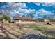 View of home from the backyard, showing the yard, trees, and blue sky with clouds at 11 Grove Ln, Hampton, GA 30228