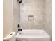 Bathroom featuring shower and tub with gray tile, niche, and black fixtures at 11 Grove Ln, Hampton, GA 30228