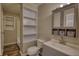 Cozy bathroom featuring built-in shelves, gray vanity with mirrored cabinet, and tub-shower combo at 11 Grove Ln, Hampton, GA 30228