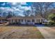 Charming brick ranch with a cozy front porch, surrounded by a well-kept lawn and mature trees at 11 Grove Ln, Hampton, GA 30228