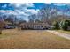 Quaint single-story home featuring a classic brick facade, a lovely front porch, and a spacious front yard at 11 Grove Ln, Hampton, GA 30228