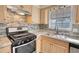Well-lit kitchen features stainless steel appliances, a stone backsplash, and a double sink with a view at 11 Grove Ln, Hampton, GA 30228