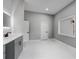 Contemporary bathroom with white tile floors, gray vanity, lighted mirrors, and natural lighting at 2150 Essex Sw Ave, Atlanta, GA 30311