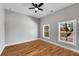 Bright bedroom featuring neutral walls, hardwood floors, a ceiling fan, and windows overlooking the neighborhood at 2150 Essex Sw Ave, Atlanta, GA 30311