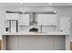 Close-up of kitchen island, stainless appliances, modern cabinets and lighting fixtures at 2150 Essex Sw Ave, Atlanta, GA 30311