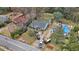 An aerial view shows the property requiring repairs, with blue tarps on the roof, a filled dumpster, and cars in the driveway at 1054 Shepherds Ne Ln, Atlanta, GA 30324