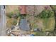 Aerial view of a residence with a car, detached garage, surrounded by lawns and mature trees at 1054 Shepherds Ne Ln, Atlanta, GA 30324