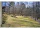 Expansive backyard with mature trees, green lawn, and a wooded border at 1300 Village Oaks Ln, Lawrenceville, GA 30043
