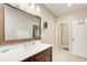 Bathroom vanity with brown cabinets, white countertop, decorative mirror, and tiled floor at 1300 Village Oaks Ln, Lawrenceville, GA 30043