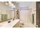 Cozy bathroom with a white vanity, large mirror, neutral walls, and a shower with a patterned curtain at 1300 Village Oaks Ln, Lawrenceville, GA 30043