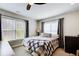 Bedroom with a plaid comforter, many windows, and neutral gray curtains at 1300 Village Oaks Ln, Lawrenceville, GA 30043