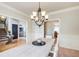 Open dining room with large chandelier adjacent to living room and entry hall at 1300 Village Oaks Ln, Lawrenceville, GA 30043