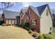 Brick and siding home with arched windows, mature landscaping, and manicured lawn at 1300 Village Oaks Ln, Lawrenceville, GA 30043