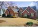Charming brick home with mature landscaping, arched window, and well-manicured lawn at 1300 Village Oaks Ln, Lawrenceville, GA 30043
