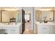 Dual vanity main bathroom with neutral color palette, mirrors, and stone tile floor at 1300 Village Oaks Ln, Lawrenceville, GA 30043