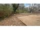 Overgrown backyard with concrete slab and untamed foliage, offering potential for landscaping or renovation at 2317 Sheryl Dr, Decatur, GA 30032