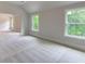 Bedroom with soft carpet, neutral walls, and many bright windows overlooking a wooded backyard at 3294 Mill Forest Sw Dr, Conyers, GA 30094