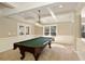 Finished basement with a billiards table, coffered ceilings, and natural light from a large window at 900 Great Rissington Way, Alpharetta, GA 30022