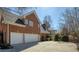 View of the side of the brick house, featuring a spacious driveway and a three-car garage at 900 Great Rissington Way, Alpharetta, GA 30022