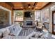 Cozy screened porch with stone fireplace, comfortable seating and ceiling fan at 900 Great Rissington Way, Alpharetta, GA 30022