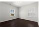 An empty bedroom showcasing neutral-toned walls, wood floor, and natural light from the windows at 13 Ganel Ln, Alpharetta, GA 30009