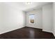 An empty bedroom showcasing neutral-toned walls, wood floor, and natural light from the window at 13 Ganel Ln, Alpharetta, GA 30009