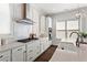 This kitchen features white cabinets, stainless steel appliances, granite countertops, and modern lighting at 13 Ganel Ln, Alpharetta, GA 30009