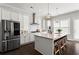 Well-equipped kitchen features a stainless steel refrigerator, an island with seating, and modern lighting at 13 Ganel Ln, Alpharetta, GA 30009