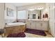 Bathroom featuring a soaking tub, double sink vanity, and tile surround at 1315 Golden Rock Se Ln # 2, Marietta, GA 30067