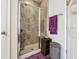 Shower with glass doors, tiled surround, and purple accent towels at 1315 Golden Rock Se Ln # 2, Marietta, GA 30067