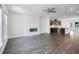 Open-concept living room with hardwood floors, a modern fireplace, and a kitchen in the background at 1745 Lansmere Sw St, Marietta, GA 30008