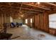 Unfinished basement offers potential for customization with exposed wood and concrete walls, awaiting your vision at 203 Overlook Ct, Dallas, GA 30157