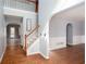 Inviting foyer with hardwood floors, staircase, and arched doorway leading to the living room at 203 Overlook Ct, Dallas, GA 30157