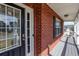 Welcoming brick front porch with storm door, painted deck, and stylish exterior lighting at 203 Overlook Ct, Dallas, GA 30157