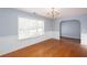 Bright living room featuring hardwood floors, natural light, wainscoting, and modern chandelier at 203 Overlook Ct, Dallas, GA 30157