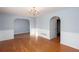 Sunny living room with hardwood floors, wainscoting, chandelier, and archway to another room at 203 Overlook Ct, Dallas, GA 30157