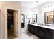 Bathroom with double sinks, dark cabinets, marble countertops, and walk-in closet access at 35 Rock Rose Dr, Covington, GA 30014