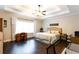 Spacious main bedroom with tray ceilings, ceiling fan, and hardwood floors at 35 Rock Rose Dr, Covington, GA 30014
