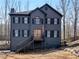 Charming two-story home with black siding, black shutters, and a stairway leading to the front entrance at 526 Lakeside Dr, Hiram, GA 30141