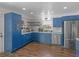 Charming kitchen with stainless steel appliances, blue cabinetry, quartz countertops, and hardwood floors at 526 Lakeside Dr, Hiram, GA 30141
