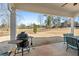 Covered patio area features grill, table, and chair seating with a beautiful backyard view at 6801 Louis Dr, Locust Grove, GA 30248