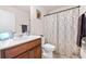 Bathroom with a wood vanity, toilet, and shower featuring a geometric pattern curtain at 6801 Louis Dr, Locust Grove, GA 30248