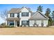Charming two-story home with white brick and siding, black shutters, and a welcoming front porch at 6801 Louis Dr, Locust Grove, GA 30248