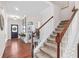 The foyer features gleaming hardwood floors and a staircase with wooden railings at 6801 Louis Dr, Locust Grove, GA 30248