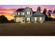 Inviting two-story home featuring a painted brick facade, covered front porch during sunset at 6801 Louis Dr, Locust Grove, GA 30248