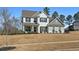 Charming two-story home with a painted brick facade, covered porch, and a well-manicured lawn at 6801 Louis Dr, Locust Grove, GA 30248