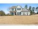 Inviting two-story home featuring a painted brick facade, covered front porch, and manicured landscaping at 6801 Louis Dr, Locust Grove, GA 30248